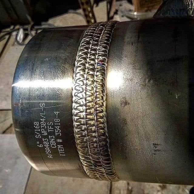 Cordon TIG pe un fiting din inox, cu marcajul piesei vizibil.