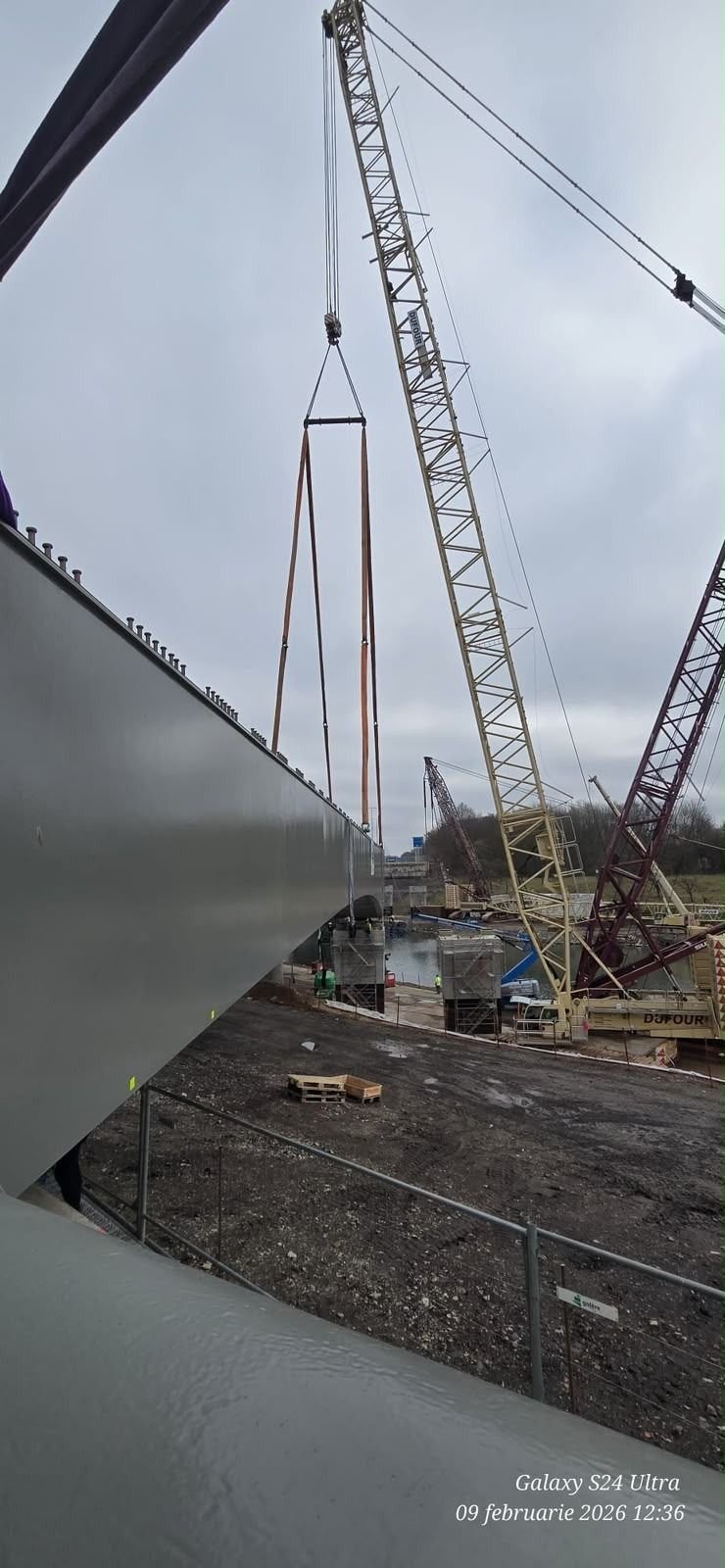 Ridicarea unei structuri metalice cu două macarale.